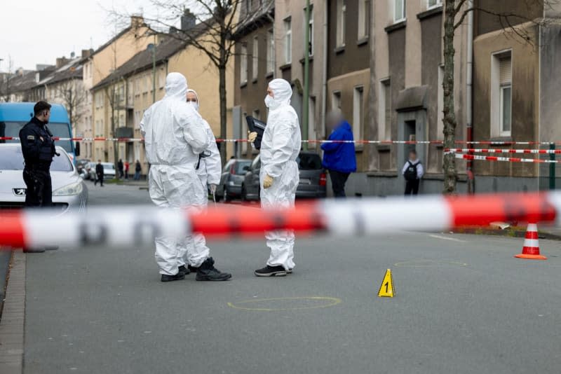 Forensics officers stand at the scene of the attack on two children, a few meters away from a school. In a small parking lot, the police have stretched flutter tape and cordoned everything off. Christoph Reichwein/dpa