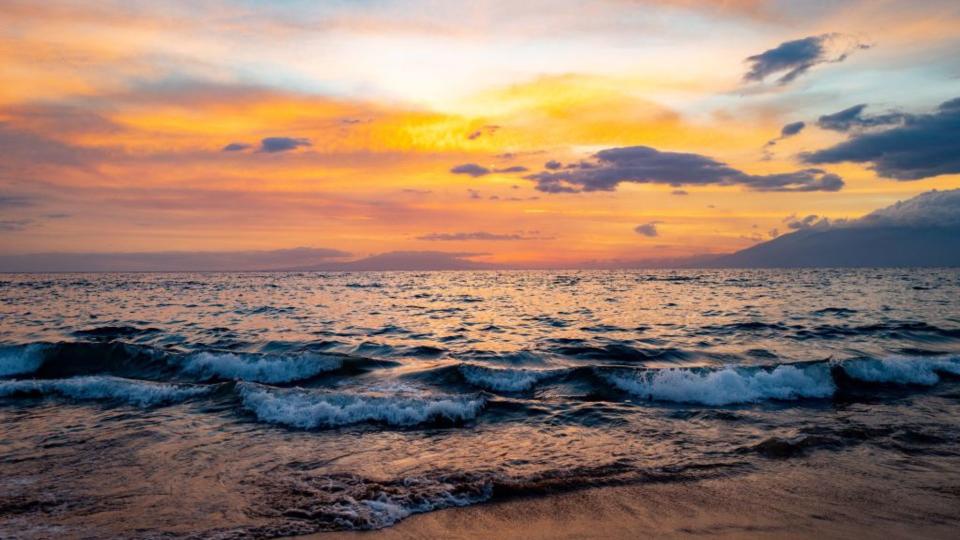 A colorful sunset is visible above Wailea Beach on the island of Maui, USA