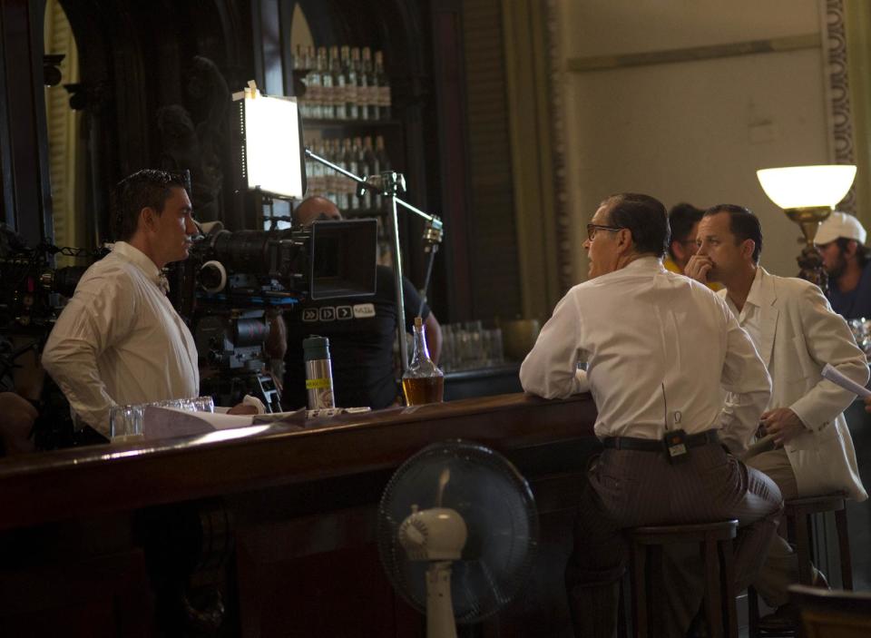 In this May 3, 2014 photo, actor Giovanni Ribisi, right and James Remar, second left, talk with the camera operator during the shooting the movie "Papa" in Havana, Cuba. An international film crew has been re-enacting this and other historic scenes from the 1950s in the streets of Havana in recent weeks for "Papa," a biopic about the budding friendship between Hemingway and a young journalist in turbulent, pre-revolution Cuba. (AP Photo/Ramon Espinosa)