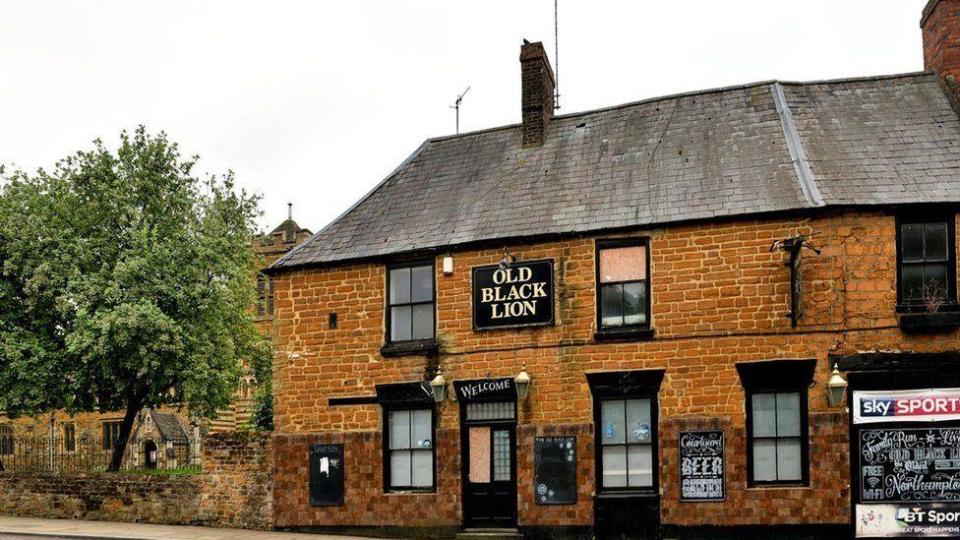 Brick-built two-storey pub building with Old Black Lion sign