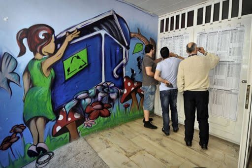 People check lists at the entrance to a polling station in Athens. Greece's two main pro-austerity parties suffered major losses in elections Sunday, exit polls showed, throwing into doubt the eurozone country's commitment to meeting the tough terms of its two bailouts