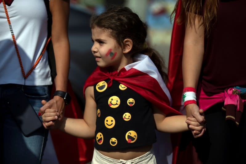 A girl takes part in a human chain organised by demonstrators during ongoing anti-government protests in Beirut