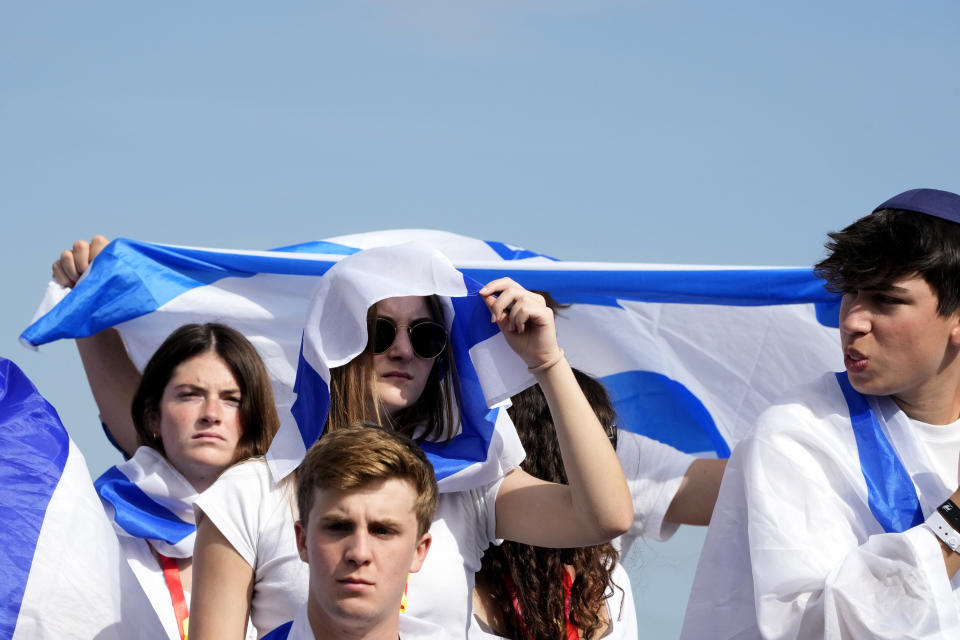 A young woman covers herself from the sun at the former Nazi German death camp of Auschwitz-Birkenau while attending the annual Holocaust remembrance event, the "March of the Living" in memory of the six million Holocaust victims in Oswiecim, Poland, Monday, May 6, 2024. The event comes amid the dramatic backdrop of the violence of the Israel-Hamas war after the Oct. 7 Hamas attack, the deadliest violence against Jews since the Holocaust, and as pro-Palestinian protests sweep U.S. campuses. (AP Photo/Czarek Sokolowski)