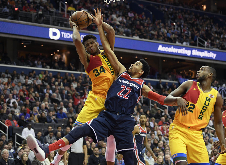 Milwaukee Bucks forward Giannis Antetokounmpo (34) grabs the rebound against Washington Wizards forward Otto Porter Jr. (22) during the first half of an NBA basketball game, Saturday, Feb. 2, 2019, in Washington. Also seen is Bucks forward Khris Middleton (22). (AP Photo/Nick Wass)