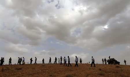 Turkish army officers warn people to leave a hill top where they were watching the Syrian town of Kobani, near the Mursitpinar border crossing on the Turkish-Syrian border, in the southeastern town of Suruc in Sanliurfa province, October 12, 2014. REUTERS/Umit Bektas