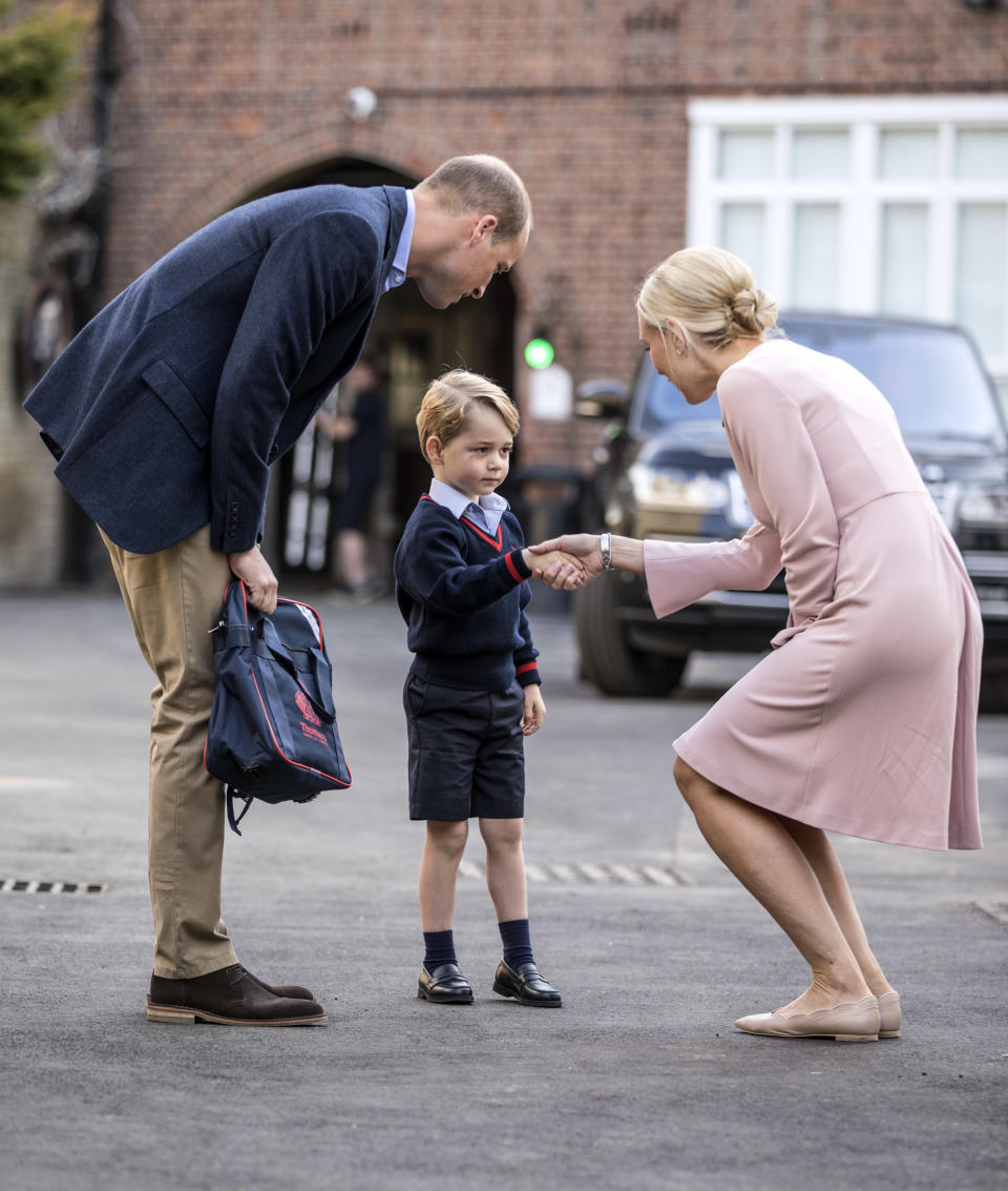 Prince William walks Prince George to his first day of school, where they were greeted by a teacher. (Photo: Getty Images)