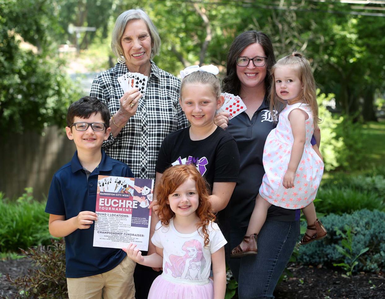 Paula Kallio, top left, and Barberton Councilwoman Tayler Thompson and Thompson’s children Michael, 7, left, Leah, 4, Madelyn, 10, and Brianna, 2, at Kallio’s home in Barberton. The women are organizing a citywide euchre tournament and proceeds will purchase school supplies for kindergarteners through fifth graders in Barberton.