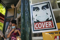 A customer exits a corner market while wearing a protective mask in the retail shopping district of the SoHo neighborhood of the Manhattan borough of New York, Friday, May 14, 2021. Gov. Andrew Cuomo has yet to say whether he will change his state’s mask mandate in light of new federal guidance that eases rules for fully vaccinated people. (AP Photo/John Minchillo)