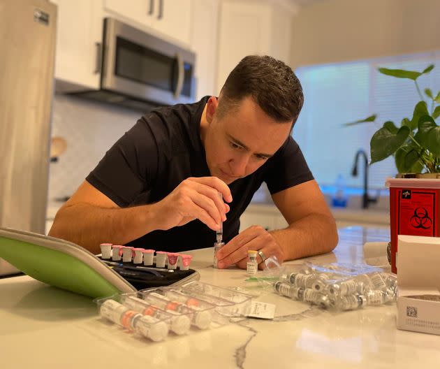 The author preparing one of two nightly injections required during the second week of the IVF cycle.