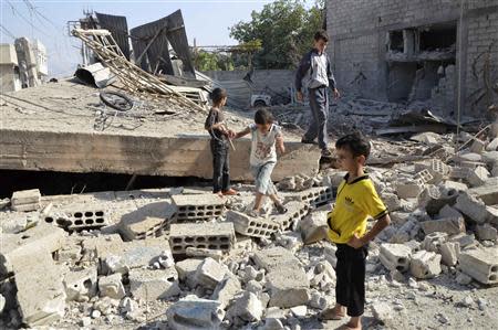 Boys walk on the rubble of a building hit by what activists said was shelling by forces loyal to Syria's President Bashar al-Assad, in the Duma neighbourhood of Damascus September 4, 2013. REUTERS/Bassam Khabieh