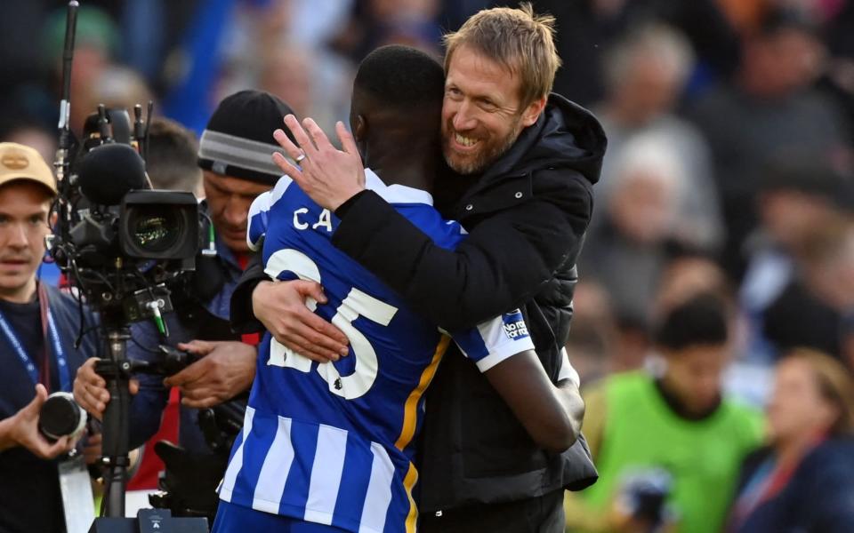 Brighton's manager Graham Potter embraces midfielder Moises Caicedo at full time - AFP