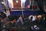 Migrants, mostly from Central America, sleep-in on the street in Huixtla, Chiapas state, Mexico, at daybreak Tuesday, Oct. 26, 2021, as they use the day to rest during their trek by foot toward the U.S. (AP Photo/Marco Ugarte)