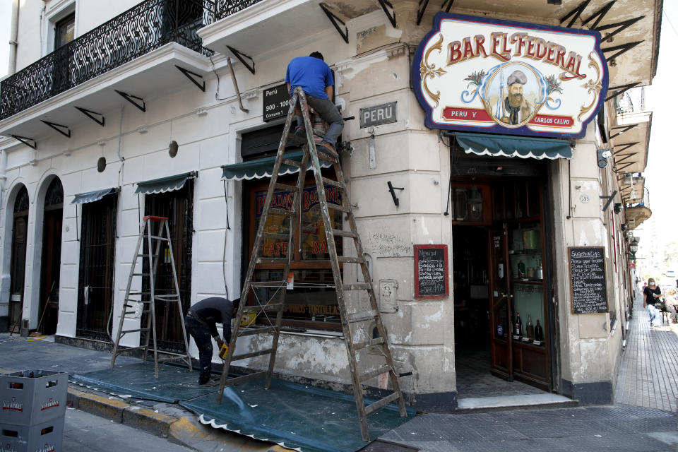 Hombres trabajan en la fachada del Bar El Federal en Buenos Aires, Argentina, el martes 10 de noviembre de 2020. (AP Foto/Natacha Pisarenko)