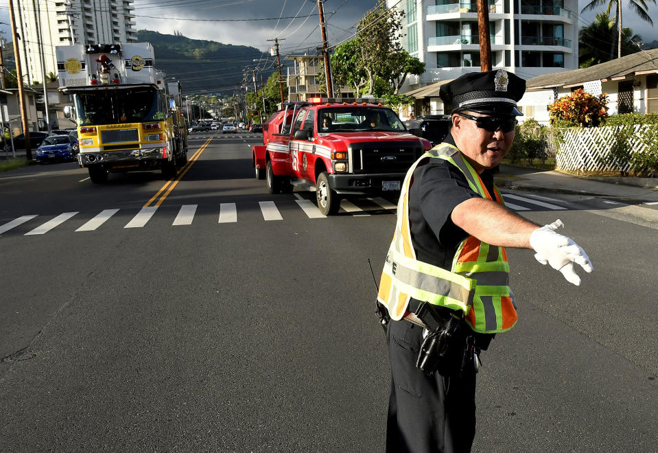 <p>A police officer directs a fire truck to the Marco Polo apartment building after a fire broke out in it in Honolulu, Hawaii, July 14, 2017. (Photo: Hugh Gentry/Reuters) </p>