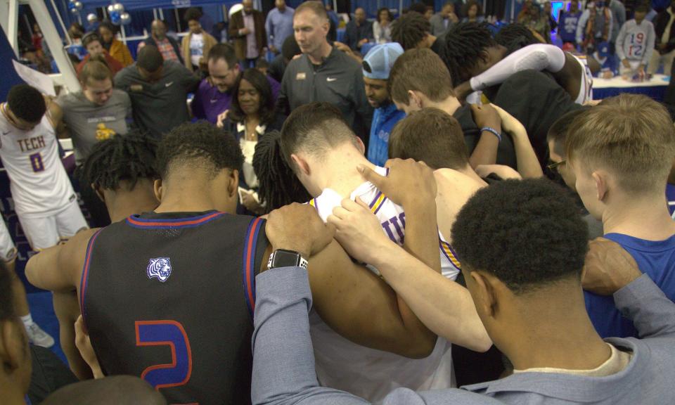 Players, coaches and school officials from Tennessee Tech and Tennessee State gather for prayers at the spot where Diante Wood was injured late in the game Saturday at Gentry Center. Wood was taken by ambulance to Vanderbilt Medical Center and the game was suspended.