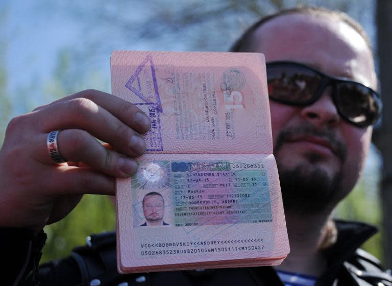 A member of the Russian Night Wolves Motorcycle Club shows his passport with his visa annulled at a border crossing with Poland near Brest on April 27, 2015