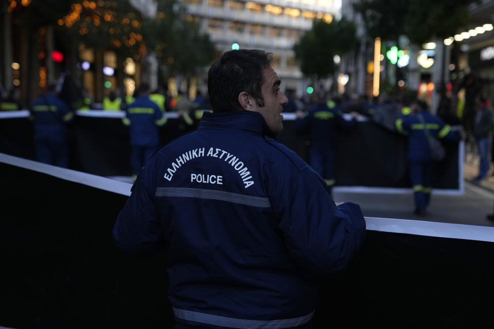 A policeman holds a banner during a protest by uniformed officers in Athens, Greece, Monday, Dec. 18, 2023. About 1,500 people took part in the rally, organized by police, firefighters and coast guard unions in response to the non-legalization of their profession as hazardous. (AP Photo/Thanassis Stavrakis)