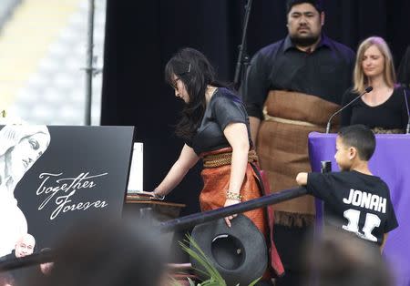Former All Black Jonah Lomu's widow Nadene Lomu touches his casket with her son Dhyreille Lomu during his memorial service in Eden Park in Auckland, New Zealand, November 30, 2015. REUTERS/Nigel Marple