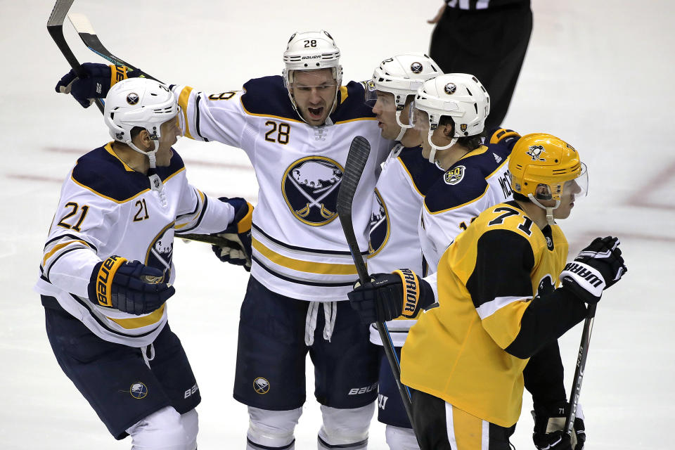 Buffalo Sabres' Zemgus Girgensons (28) celebrates his goal as Pittsburgh Penguins' Evgeni Malkin (71) skates back to his bench during the first period of an NHL hockey game in Pittsburgh, Saturday, Feb. 22, 2020. (AP Photo/Gene J. Puskar)