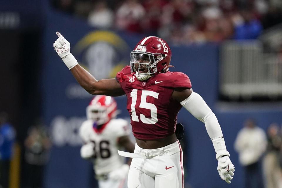 Alabama linebacker Dallas Turner holds up an arm and pointer finger and celebrates after making a stop.