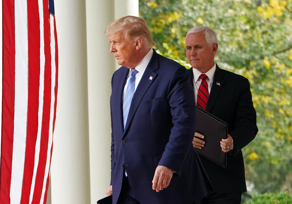 President Trump and Vice President Mike Pence next to an American flag and columns outside the White House