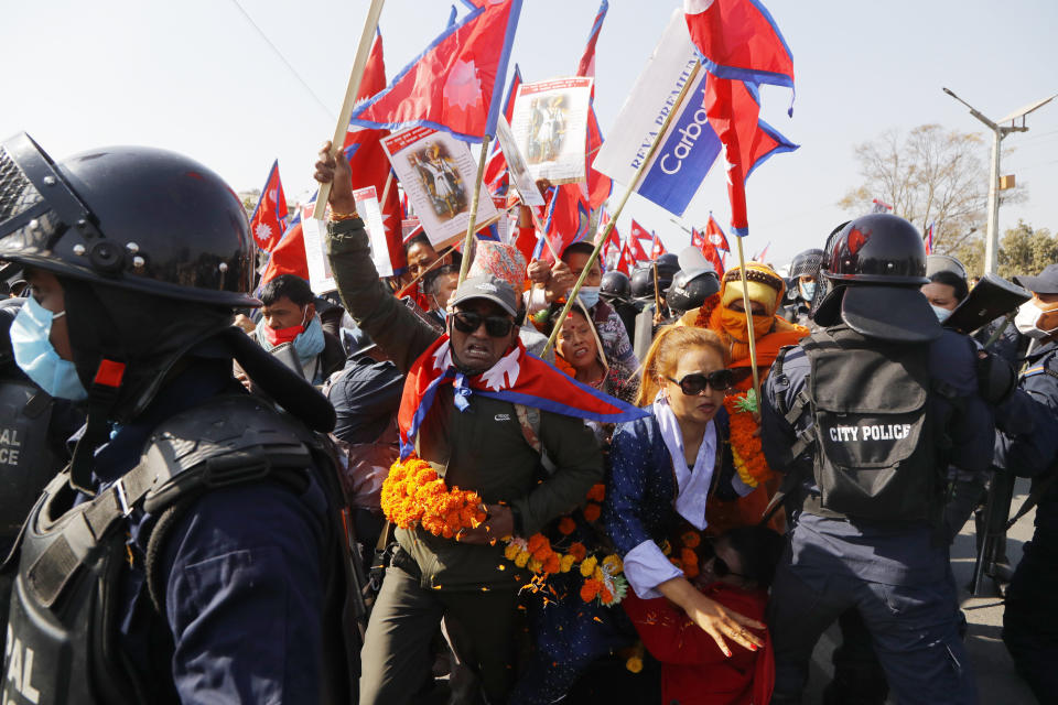 Pro-king supporters are stopped by riot police as they march demanding reinstating monarchy that was abolished more than a decade ago in Kathmandu, Nepal, Monday, Jan.11, 2021. Monday's protest was the latest anti-government protest against Prime Minister Khadga Prasad Oli who has been facing street demonstrations against him from a splinter faction of his own Communist party and more from opposition political groups for dissolving parliament. Nepal's centuries-old monarchy was abolished in 2008 by the parliament and replaced by a republic where the president was elected as the head of state. (AP Photo/Niranjan Shrestha)