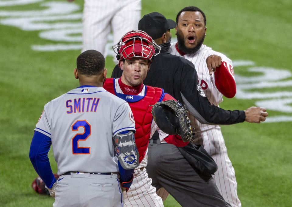 Philadelphia Phillies relief pitcher Jose Alvarado, right, has an altercation with New York Mets' Dominic Smith (2) as catcher Andrew Knapp tries to intervene after Smith struck out swinging in the eighth inning of a baseball game, Friday, April 30, 2021, in Philadelphia. (AP Photo/Laurence Kesterson)