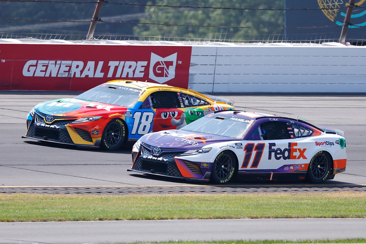 LONG POND, PA - JULY 24:  Denny Hamlin (#11 Joe Gibbs Racing FedEx Office Toyota)  and Kyle Busch (#18 Joe Gibbs Racing M&M's Toyota) drive during the NASCAR Cup Series M&MS Fan Appreciation 400 on July 24, 2022 at Pocono Raceway in Long Pond, Pennsylvania.   (Photo by Rich Graessle/Icon Sportswire via Getty Images)