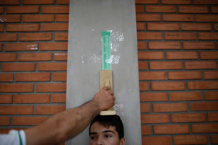A child gets his height measured during a health program of the NGO "Comparte por una vida" (Share for a life) at La Frontera school in Cucuta, Colombia February 5, 2019. Picture taken February 5, 2019. REUTERS/Marco Bello