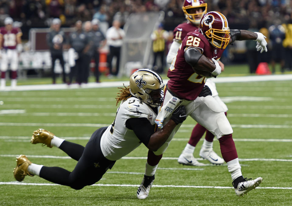 Washington Redskins running back Adrian Peterson (26) carries against New Orleans Saints defensive end Cameron Jordan (94) in the first half of an NFL football game in New Orleans, Monday, Oct. 8, 2018. (AP Photo/Bill Feig)