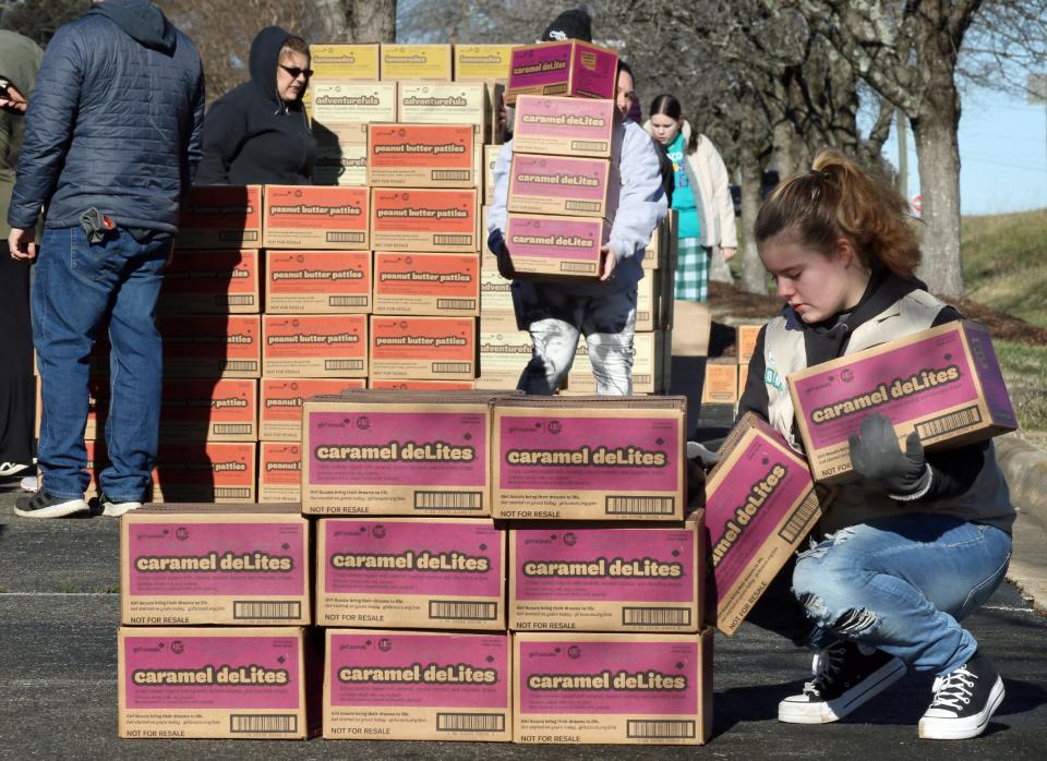 Thirteen-year-old Abby Smith helps restack Carmel DeLites after several pallets of Girl Scout cookies were unloaded early Saturday morning, Jan. 13, 2024, in the parking lot of Aldersgate UMC in Shelby.