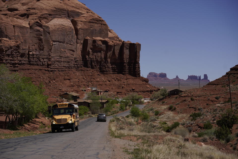 FILE - A school bus moves up Rock Door Canyon Rd., in Oljato-Monument Valley, Utah, on the Navajo reservation, April 27, 2020. The U.S. Federal Energy Regulatory Commission has rejected several proposed hydropower projects on the largest Native American reservation in the U.S. The commission has also created a policy that essentially gives tribes veto power over such projects early on. (AP Photo/Carolyn Kaster, File)