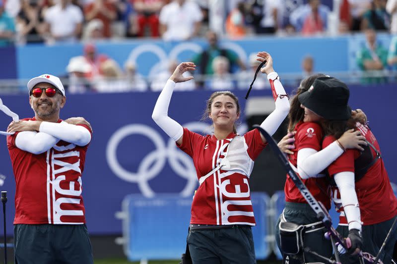 Integrantes del equipo femenino de tiro con arco festejan junto a su entrenador la conquista de la medalla de bronce para México