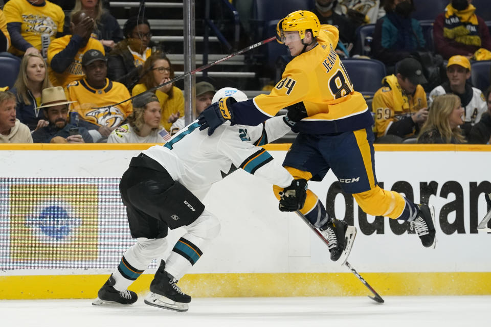 Nashville Predators left wing Tanner Jeannot (84) jumps to get past San Jose Sharks defenseman Jacob Middleton (21) in the second period of an NHL hockey game Tuesday, Oct. 26, 2021, in Nashville, Tenn. (AP Photo/Mark Humphrey)