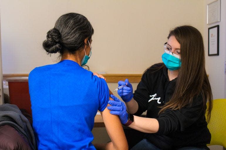 Medical assistant Shelby Davis gives an inoculation at one of the Portland, Maine, area's school-based health centers.