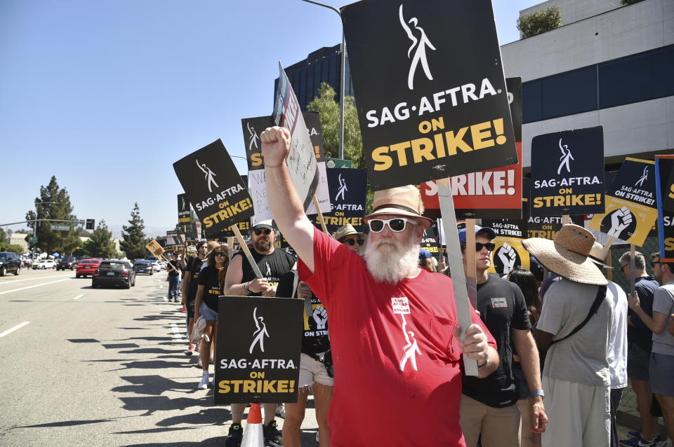 Picketers carry signs on the picket line outside Universal Studios on Friday, Aug. 4, 2023, in Universal City, Calif. The actors strike comes more than two months after screenwriters began striking in their bid to get better pay and working conditions. (Photo by Richard Shotwell/Invision/AP)