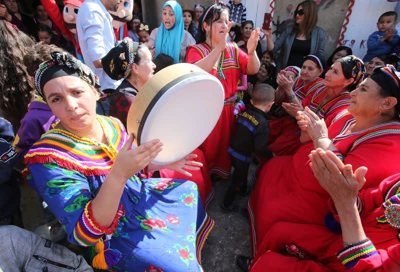 Aida, 41, plays the drum during a ceremony ahead of her soccer match in the village of Sahel