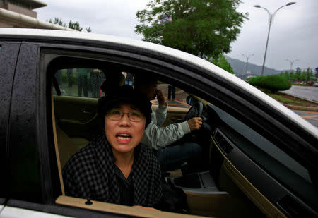 FILE PHOTO: Liu Xia, wife of jailed Nobel Peace Prize Laureate Liu Xiaobo, looks out of a car window after a trial outside a court in the Huairou district of Beijing, China June 9, 2013. REUTERS/Petar Kujundzic/File Photo