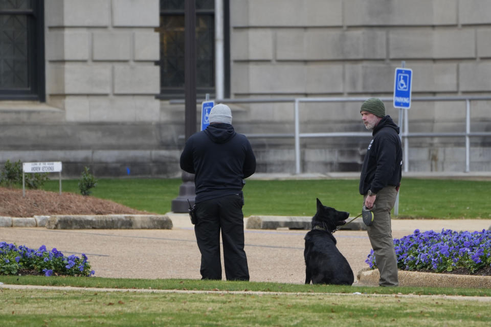 An ordinance sniffing dog patrols the Mississippi State Capitol grounds as Capitol Police respond to a bomb threat at the state building in Jackson, Miss., Wednesday morning, Jan. 3, 2024. The structure was emptied and the grounds cleared of vehicles as officers investigated. (AP Photo/Rogelio V. Solis)