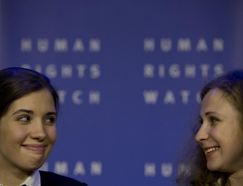 Russian punk band Pussy Riot members Nadezhda Tolokonnikova, and Maria Alekhina, right, glance at each when responding to questions from the media during a press conference as part of a human rights weekend in Amsterdam, Netherlands, Friday, Jan. 31, 2014. Tolokonnikova and Alekhina were released from prison last month after serving 21 months for hooliganism following their March 2012 arrest for giving an unauthorized performance in Christ The Savior Cathedral in Moscow, Russia. (AP Photo/Peter Dejong)