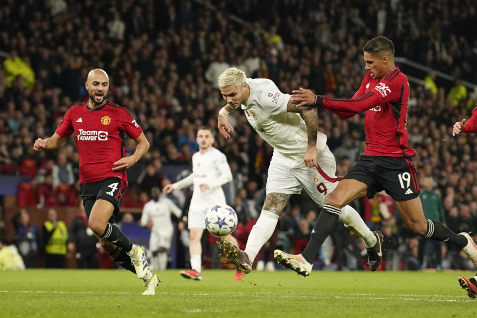 Galatasaray's Mauro Icardi, centre, scores his side's third goal during the Champions League group A soccer match between Manchester United and Galatasaray at the Old Trafford stadium in Manchester, England, Tuesday, Oct. 3, 2023. (AP Photo/Dave Thompson)