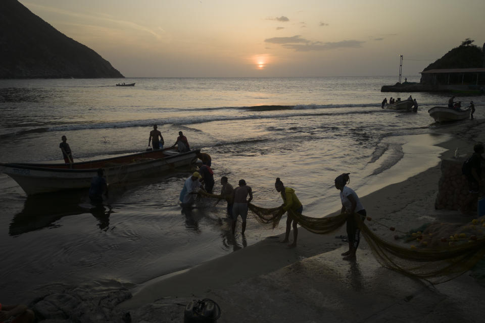 La pescadora María Reyes y sus colegas sacan una red para colocarla en la playa después de un día de pesca, en Chuao, Venezuela, el jueves 8 de junio de 2023. Las mujeres de las comunidades costeras de Choroní y la vecina Chuao, que alguna vez estuvieron relegadas a cocinar o limpiar en albergues, pensiones y comedores, se han ganado el respeto de los hombres con quienes trabajan ahora para pescar miles de kilos de pescado al día. (AP Foto/Matias Delacroix)