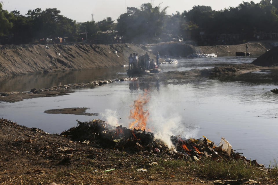 Trash left behind by Central American migrants is burned, set fire by locals who operate the small ferries on the Suchiate River near Ciudad Hidalgo, Mexico, Friday, Jan. 24, 2020, a location popular for migrants to cross from Guatemala to Mexico. (AP Photo/Marco Ugarte)