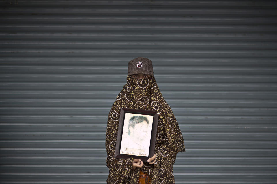 Somi Baloch, 16, poses for a portrait holding a photograph of her brother Deen, who went missing on June 28, 2009, while she and other relatives take a break from a long march protest, in Rawalpindi, Pakistan, Friday, Feb. 28, 2014. She is part of a group of activists from the impoverished southwestern province of Baluchistan who walked roughly 3,000 kilometers (1,860 miles) to the capital of Islamabad to draw attention to alleged abductions of their loved ones by the Pakistani government. (AP Photo/Muhammed Muheisen)