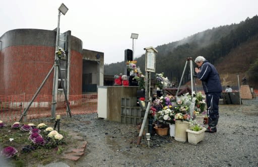 A man prays in front of the former Okawa elementary school in Ishinomaki, Miyagi Prefecture on the eighth anniversary of the 2011 tsunami disaster