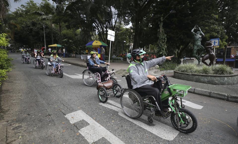 Wilson Guzmán hace de guía de un grupo de turistas que recorren Medellín en sillas de ruedas eléctricas fabricadas por un empresario local que quiere ofrecer a los discapacitados una alternativa barata para movilizarse. (AP Photo/Fernando Vergara)