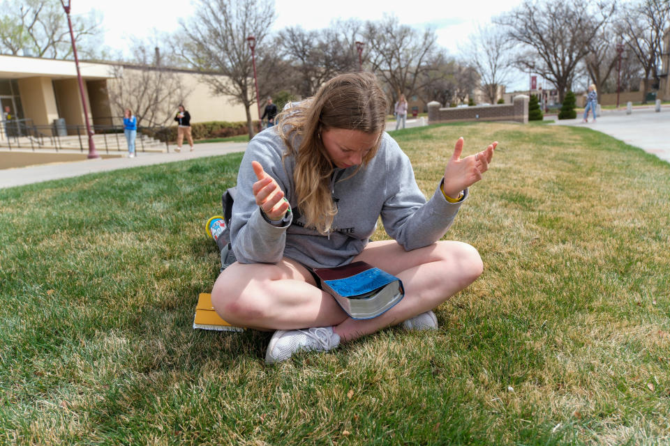 A student prays Thursday at a protest about a drag show being canceled at West Texas A&M University in Canyon.