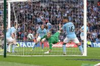 Wigan Athletic's Ben Watson (not in picture) scores the winning goal past a helpless Manchester City goalkeeper Joe Hart (centre)