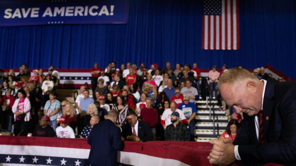 <div>Michigan State Rep. Matt Maddock bows his head during a prayer as people gather for a Save America rally on October 1, 2022 in Warren, Michigan. Trump has endorsed Republican gubernatorial candidate Tudor Dixon, Secretary of State candidate Kristina Karamo, Attorney General candidate Matthew DePerno, and republican businessman John James ahead of the November midterm election.</div> <strong>(Photo by Emily Elconin/Getty Images)</strong>