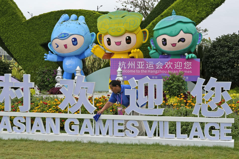 A staff member cleans an Asian Games sign ahead of the 19th Asian Games in Hangzhou, China, Thursday, Sept. 21, 2023. The Asian Games are an attention grabber. For starters, they involve more participants than the Summer Olympics. Organizers say more than 12,000 will be entered as the opening ceremony takes place Saturday, Sept. 23 in the eastern Chinese city of Hangzhou. (AP Photo/Ng Han Guan)